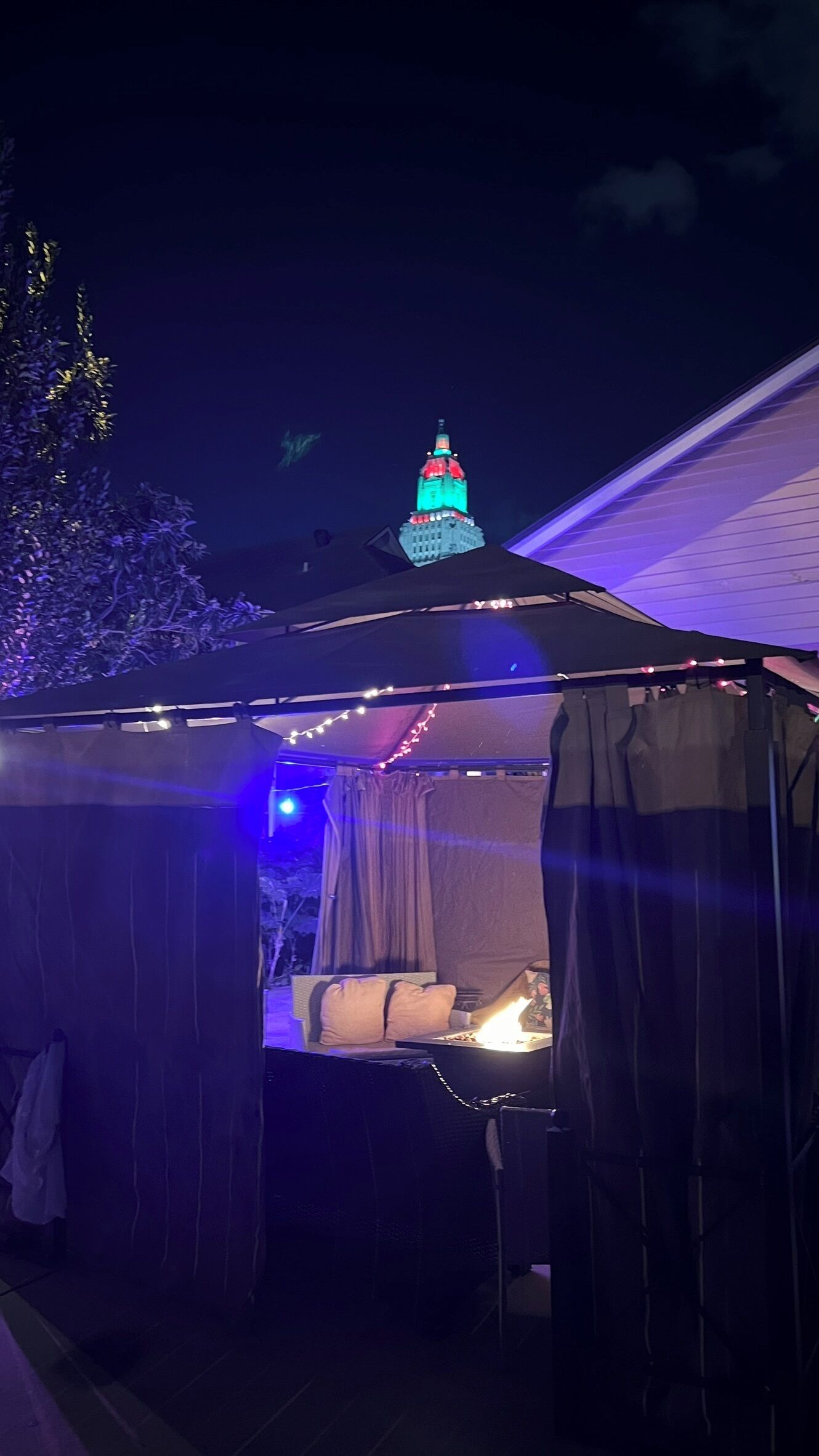 Una estructura semblant a una tenda amb un llit i una taula amb una espelma.