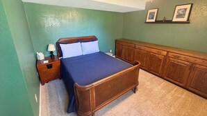 A bedroom with a bed, nightstand, dresser, and ceiling fan.