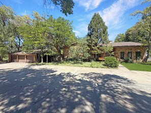 A residential property with a garage, a stone house, and a well-maintained lawn.