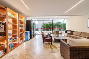 Un intérieur moderne comprenant un coin cuisine, un espace salon et de grandes fenêtres.