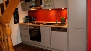 Eine moderne Küche mit weißen Schränken, einem eingebauten Backofen und einer Spüle.