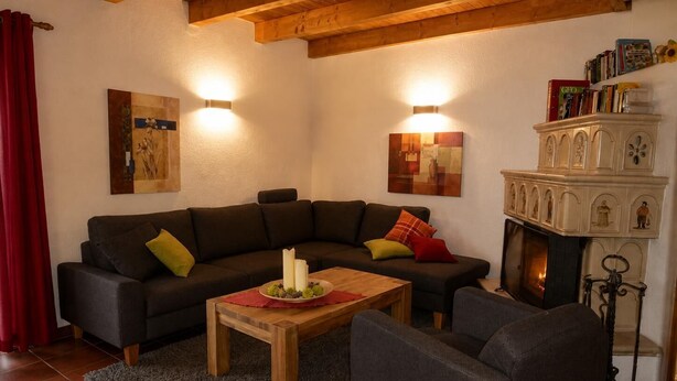 A living room with a sectional sofa, a wooden coffee table, and a fireplace.