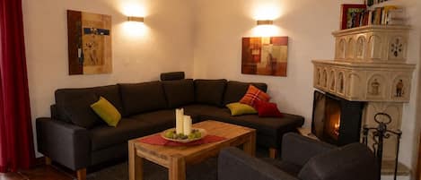 A living room with a sectional sofa, a wooden coffee table, and a fireplace.