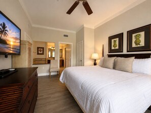 A hotel room with a bed, a desk, a chair, a TV, and framed pictures on the wall. - Reunion Resort 3BR | Beautiful Views + Pool Access (Kissimmee)