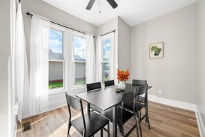 A dining area with a table, chairs, and a vase of flowers. - Roadmap Lodging: Solo Traveler 1BR, Own Entrance (Columbus)