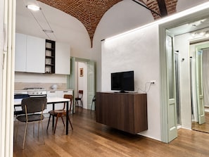 A modern kitchen with white cabinets, a wooden dining table, and chairs.