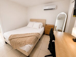 A bedroom with a bed, bedside table, chair, and a mirror. - Cozy Poolside Guest House-Gazebo + Free Parking (West Park)