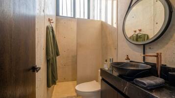 Un baño con inodoro, lavamanos y espejo.