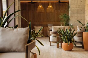 Un intérieur moderne avec un espace salon, des murs lambrissés et des luminaires suspendus.