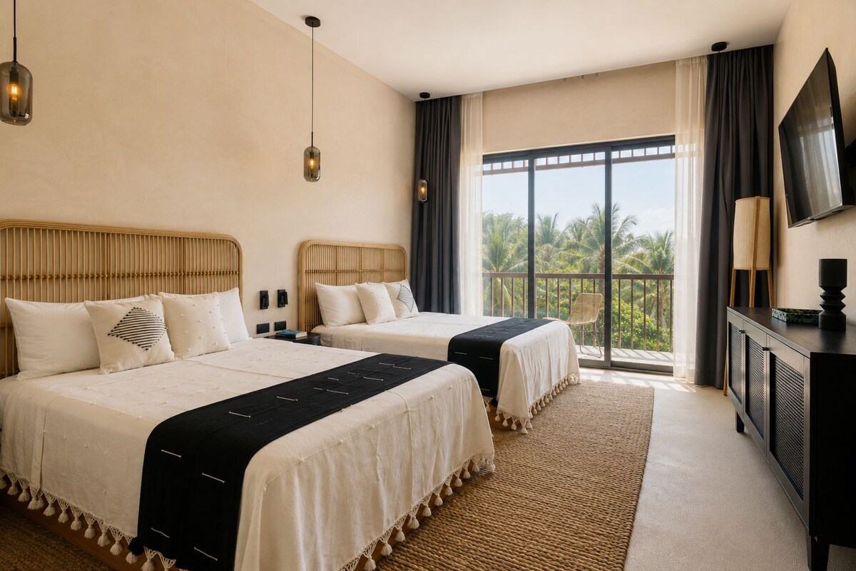Habitación de hotel con dos camas, un ventanal con vistas, un televisor de pantalla plana y un balcón.
