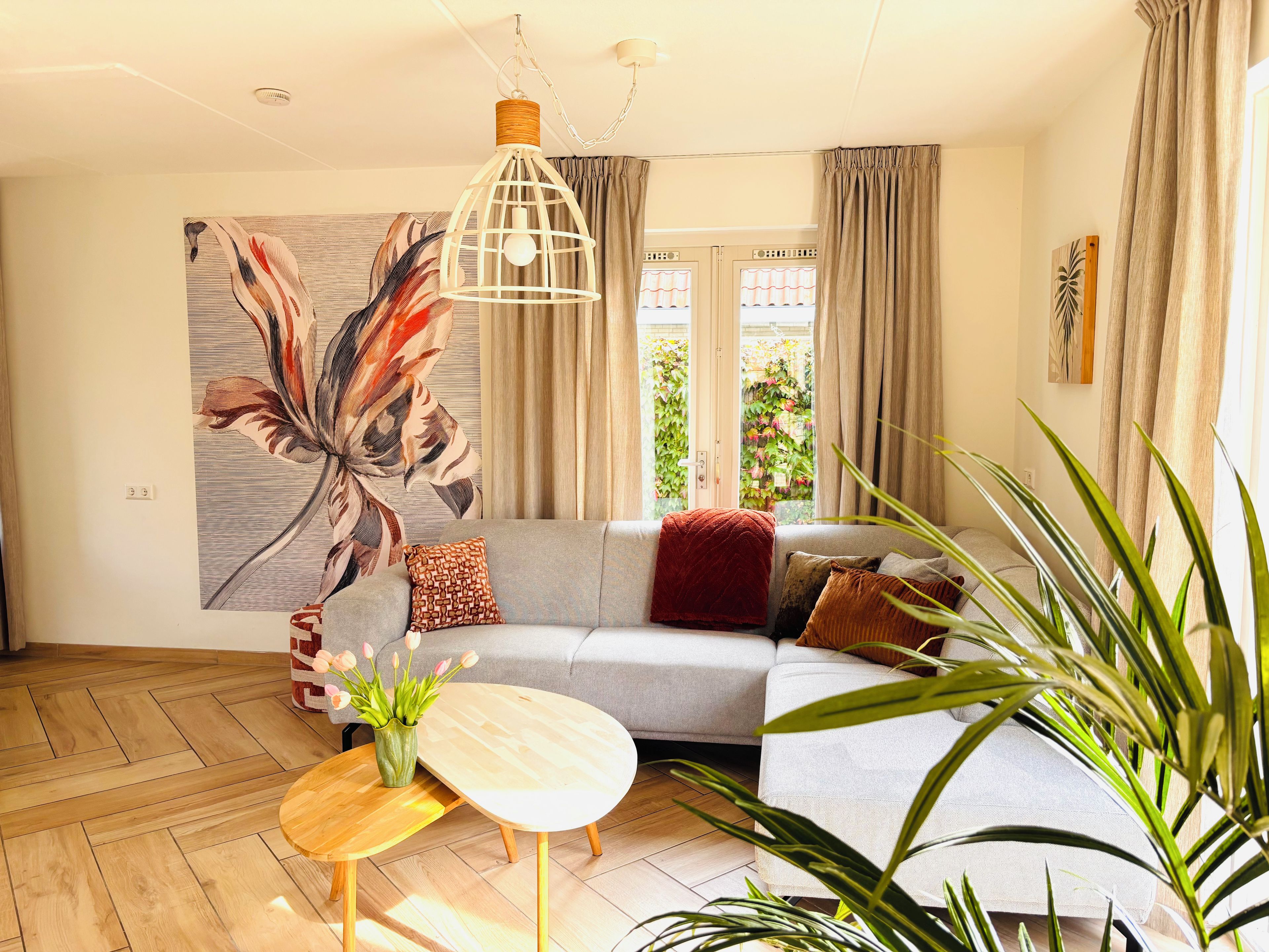 Ein modernes Wohnzimmer mit einem Ecksofa, einem runden Holztisch und einem großen abstrakten Gemälde.