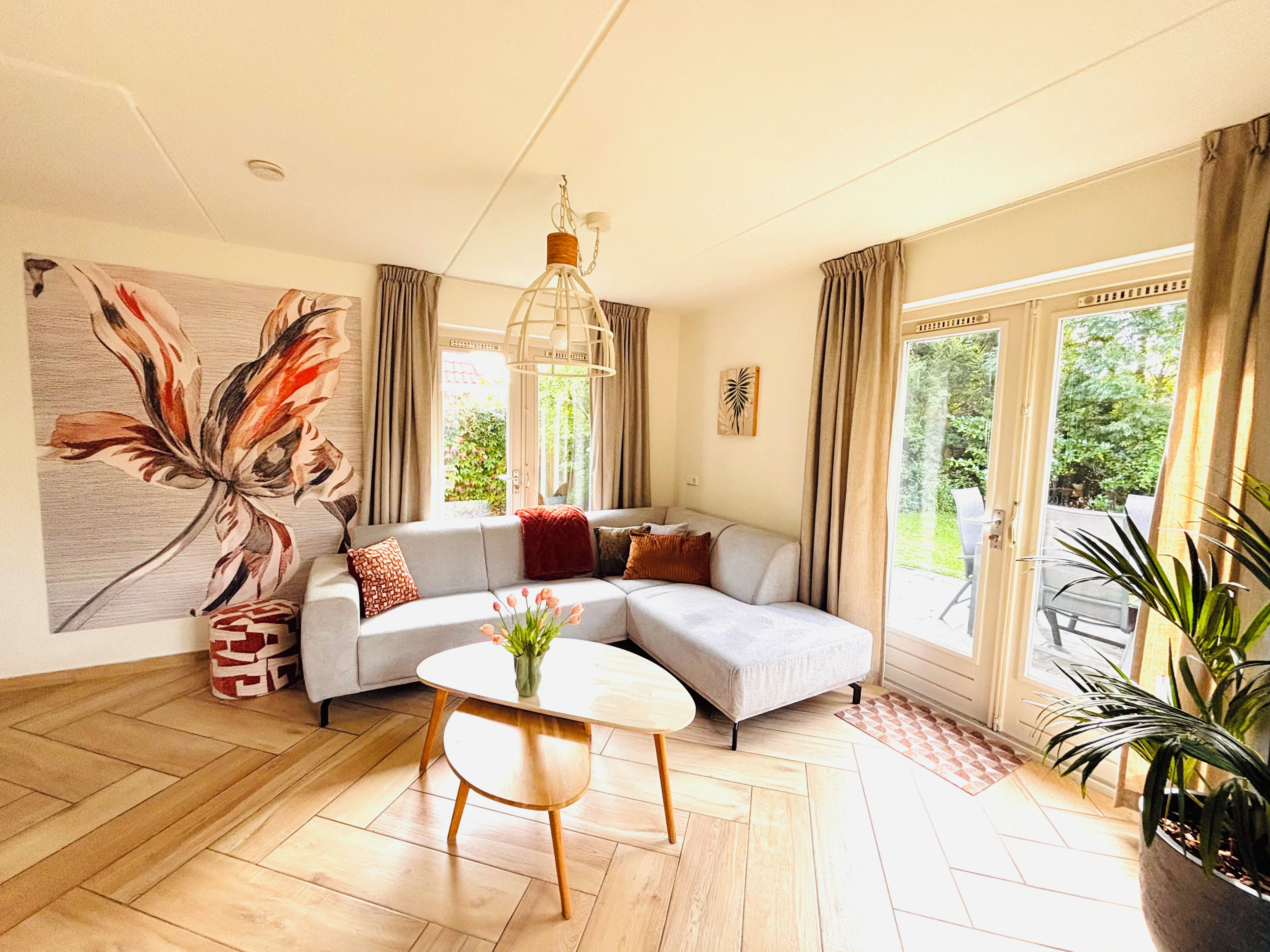 A modern living room with a sectional sofa, a round coffee table, and a large window with curtains.