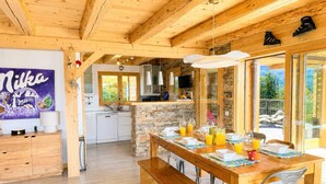 Un interior de madera con cocina, comedor y vistas al exterior.