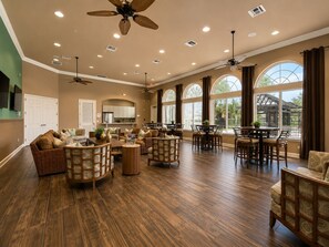 A spacious living area with a high ceiling, multiple ceiling fans, and large windows providing natural light. - 6-bedroom Lakeview Pool House in Resort at Kissimmee/No Carpet/Close to Parks (Kissimmee)