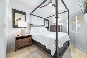 Ein Himmelsbett mit Kopfteil, Nachttischen und einem Beistelltisch.