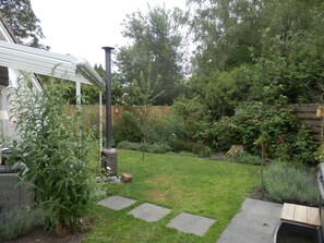 A garden with a patio area, a chimney, and various plants. - Family Villa With Jacuzzi & Large Garden (Balkbrug)