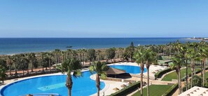 A resort with multiple swimming pools, a beach, and palm trees. - Two-story penthouse right on the beach. Dream Subdivision (AN)