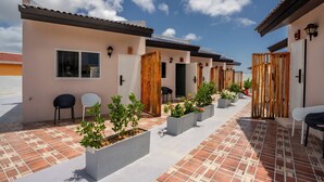 A courtyard with tiled flooring, potted plants, and outdoor seating. - Aruba Vibe Apartments #1 | Charming Studio Near the Beaches and Downtown (Oranjestad)