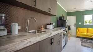 A modern kitchen with a built-in sink, a coffee maker, and a toaster. - Aruba Vibe Apartments #1 | Charming Studio Near the Beaches and Downtown (Oranjestad)