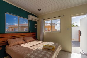 Een slaapkamer met een bed, een raam en een airconditioning.