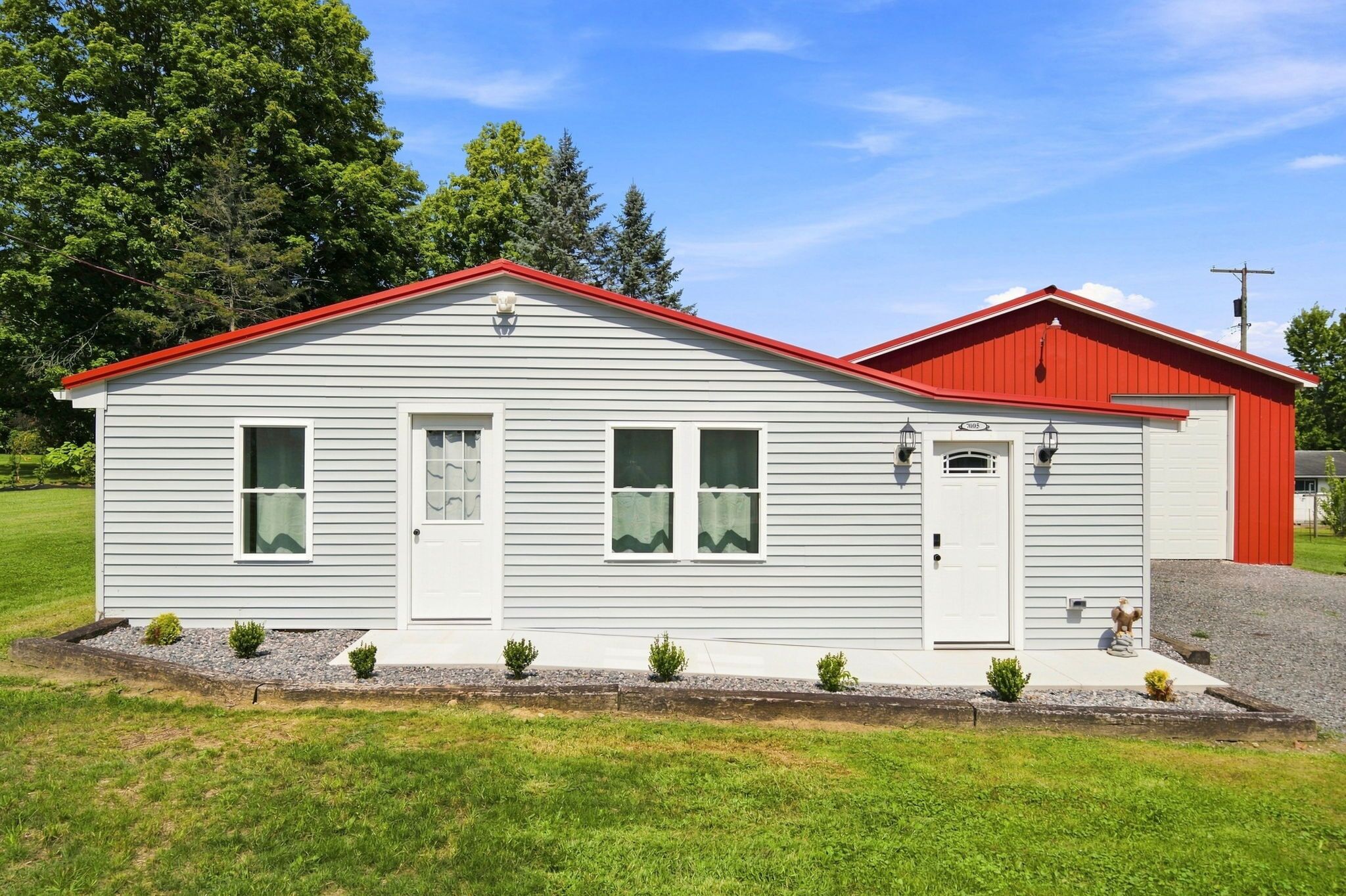 A single-story building with a red roof, white siding, and a small front porch.