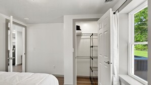 Quarto com cama, closet espaçoso e janela com vista.