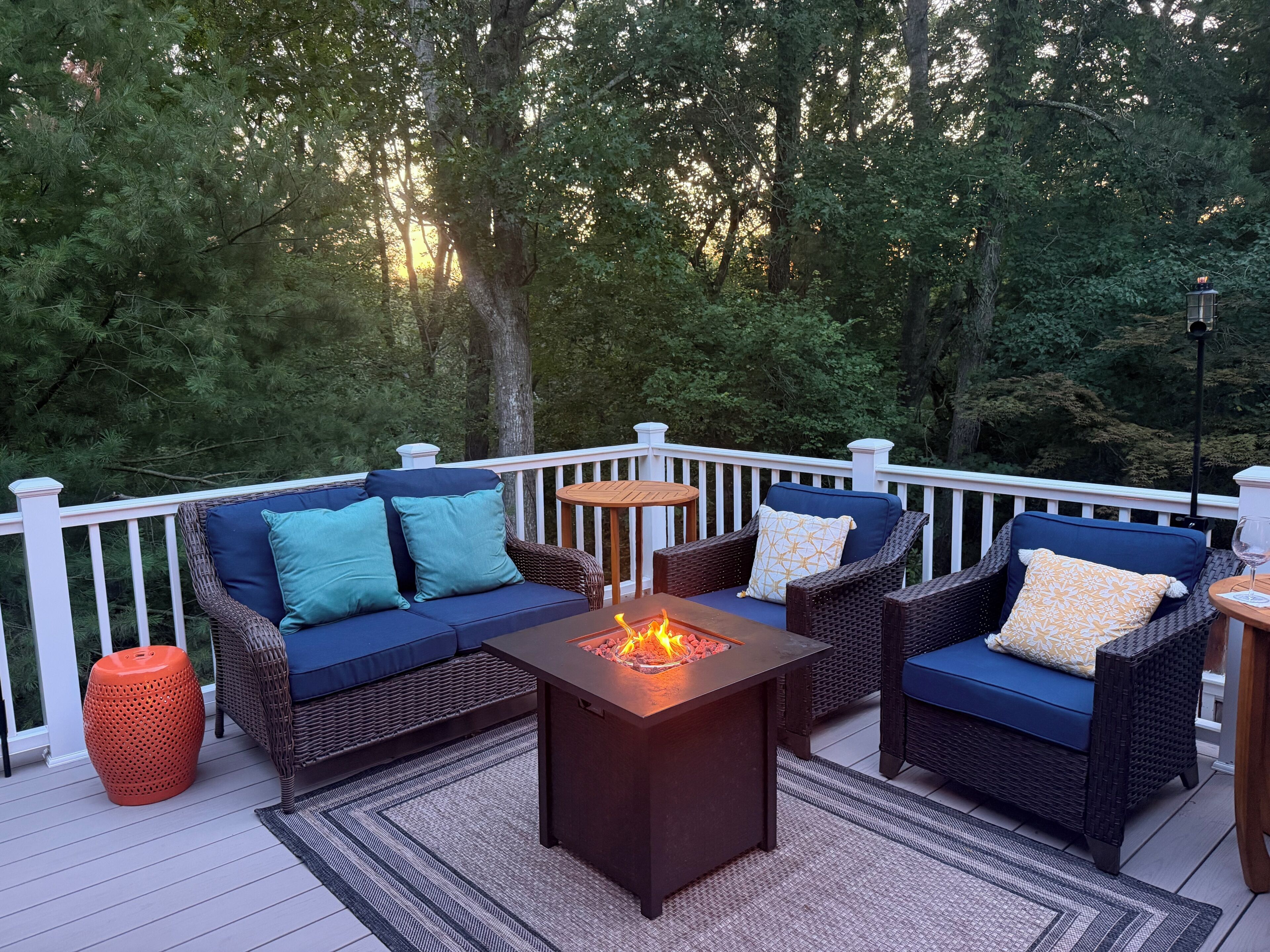A deck with outdoor furniture, a fire pit, and a lantern.