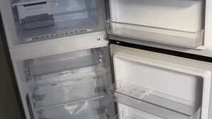 A refrigerator with multiple transparent storage drawers and a pull-out tray.