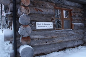 A log cabin with a sign indicating its name and address. - Ruka Chalet Roma | Traditional 2BR Log Apt | Sauna (Ruka)