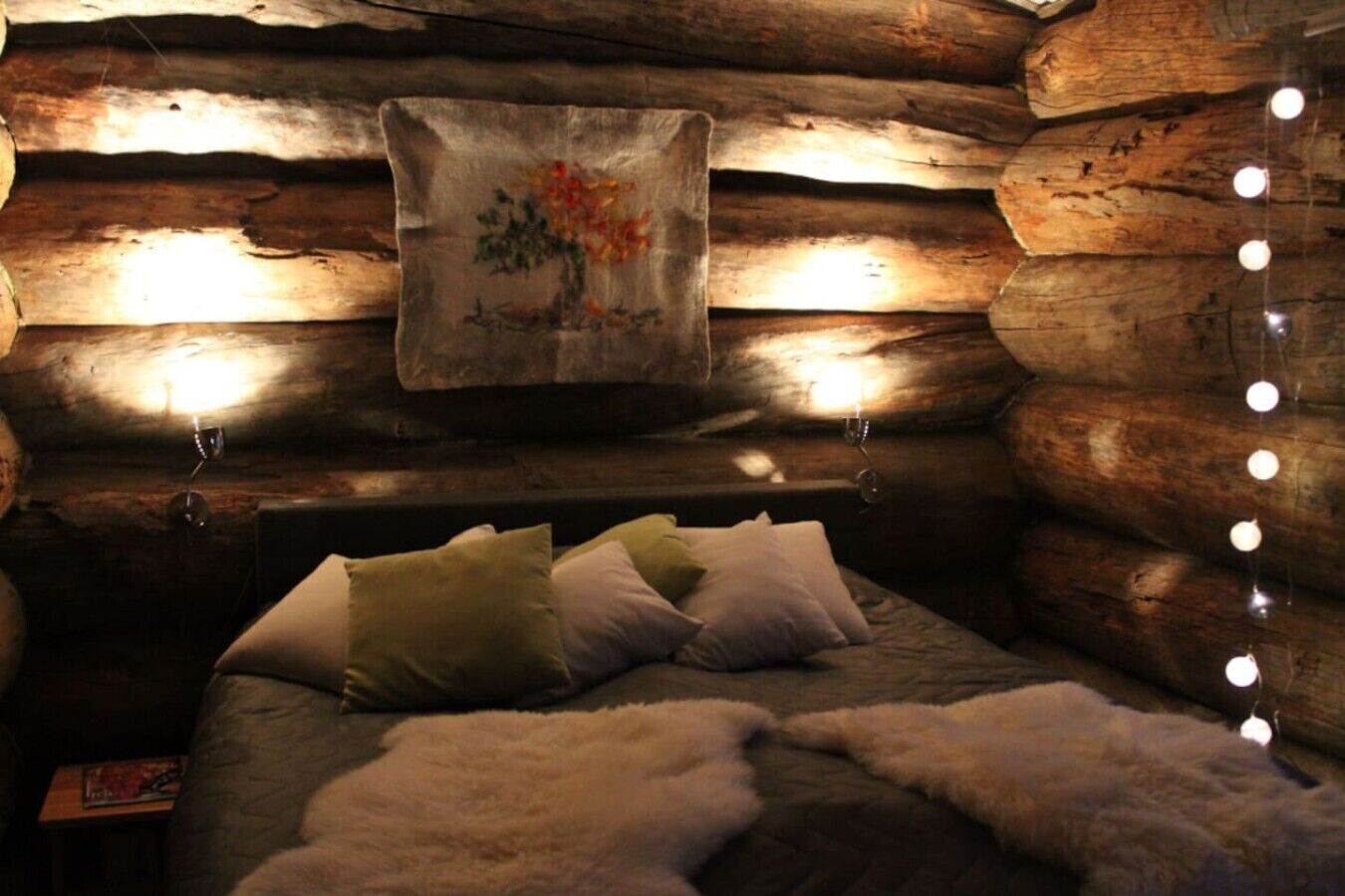 Ein gemütliches Schlafzimmer in einer Blockhütte mit einem Bett, Kissen und einer Wandteppich.