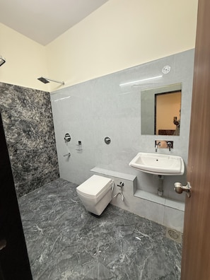 Un baño con inodoro, lavabo y zona de ducha.