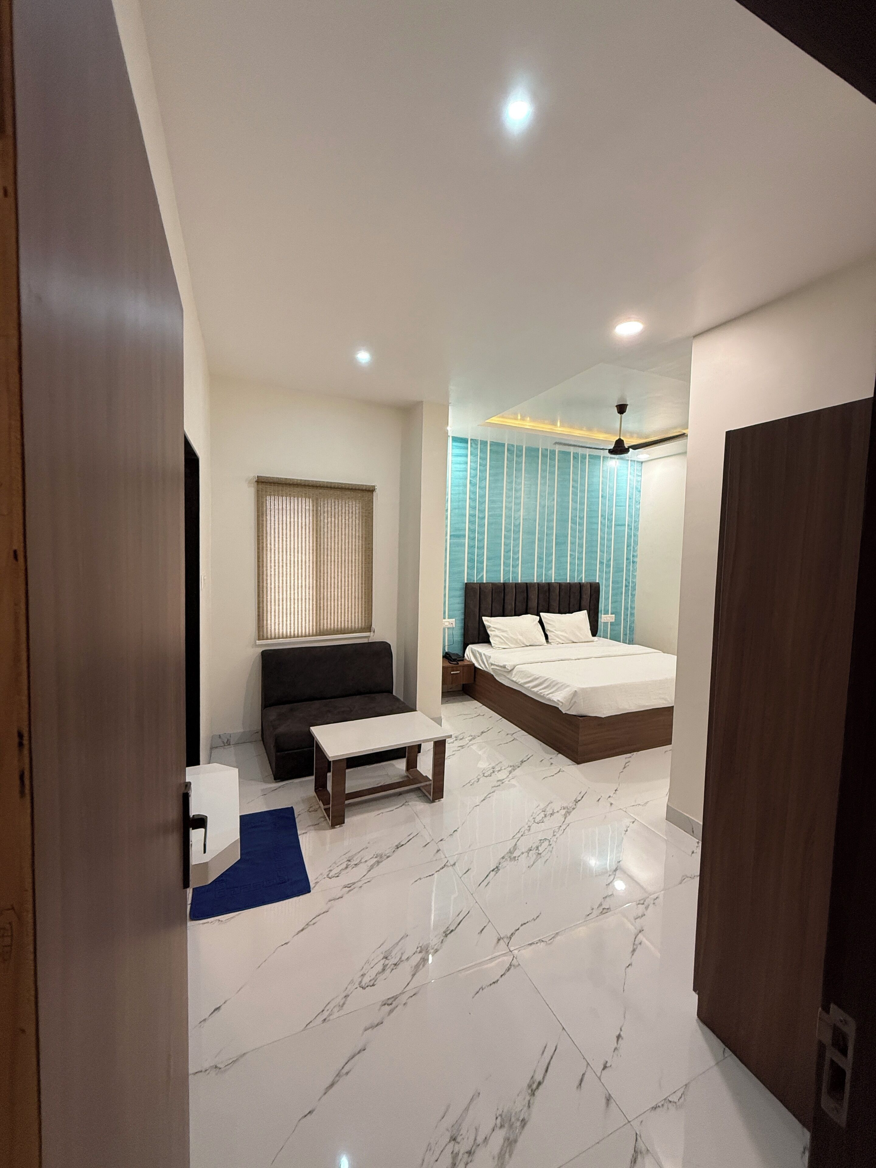 A modern bedroom with a bed, bedside table, and a sofa.