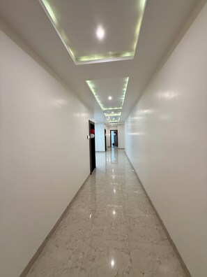 Un couloir doté d’un sol en marbre et d’un éclairage encastré.