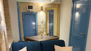 Una habitación con un sofá azul, una mesita y una mesa de centro de mármol.