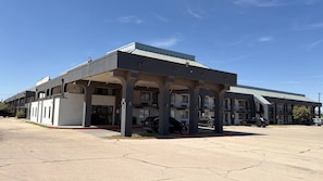 A motel with a covered parking area and multiple rooms. - The Executive Inn & Suites Midland (Midland)