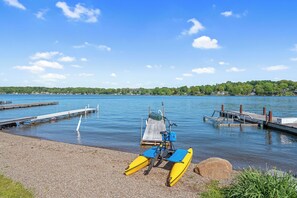 A calm lake with a dock and a kayak. - Shoreline Retreat - New Modern Luxury Waterfront Escape -Dock & Water Toys (Sterling)