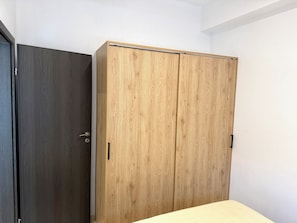 Ein Zimmer mit einem dunklen und einem hellen Holzschrank.
