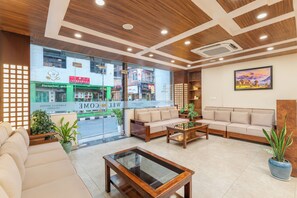 A hotel lobby with a sofa, a coffee table, and a reception desk. - Aarohan Hotel Thamel (Kathmandu)