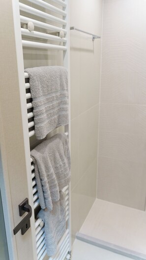 A bathroom with a white towel rack holding multiple towels. - καινούριο άνετο διαμέρισμα με μπαλκόνια και πάρκινγκ. Πλήρες εξοπλισμένο (CHIOS)