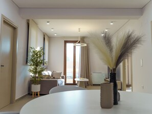 A modern living room with a round table, a sofa, a potted plant, and a vase with dried pampas grass. - καινούριο άνετο διαμέρισμα με μπαλκόνια και πάρκινγκ. Πλήρες εξοπλισμένο (CHIOS)