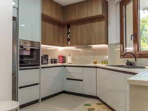 Eine moderne Küche mit Backofen, Kaffeemaschine und Spüle.