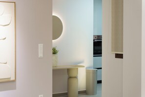A modern interior with a minimalist design, featuring a round mirror, a small table with a vase, and a patterned wall. - κ αινούριο άνετο διαμέρισμα με μπαλκόνια και πάρκινγκ. Πλήρες εξοπλισμένο (CHIOS)