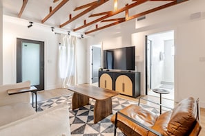 A modern living room with a sofa, a coffee table, a TV, and a cabinet. - 4BR Miaminear Design Districtbig Yard & Fire Pit (Miami)