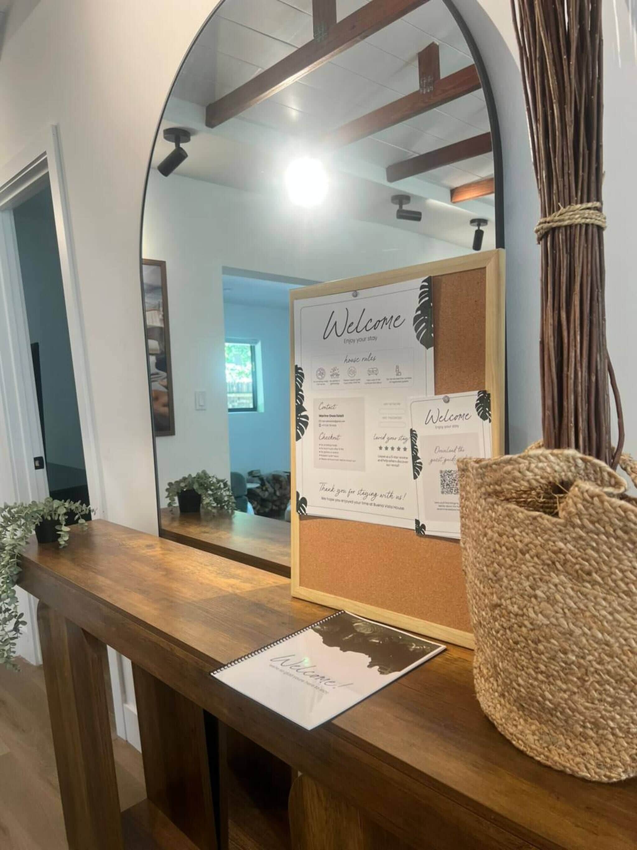 A reception area with a corkboard displaying a welcome message, a framed welcome sign, and a guestbook.