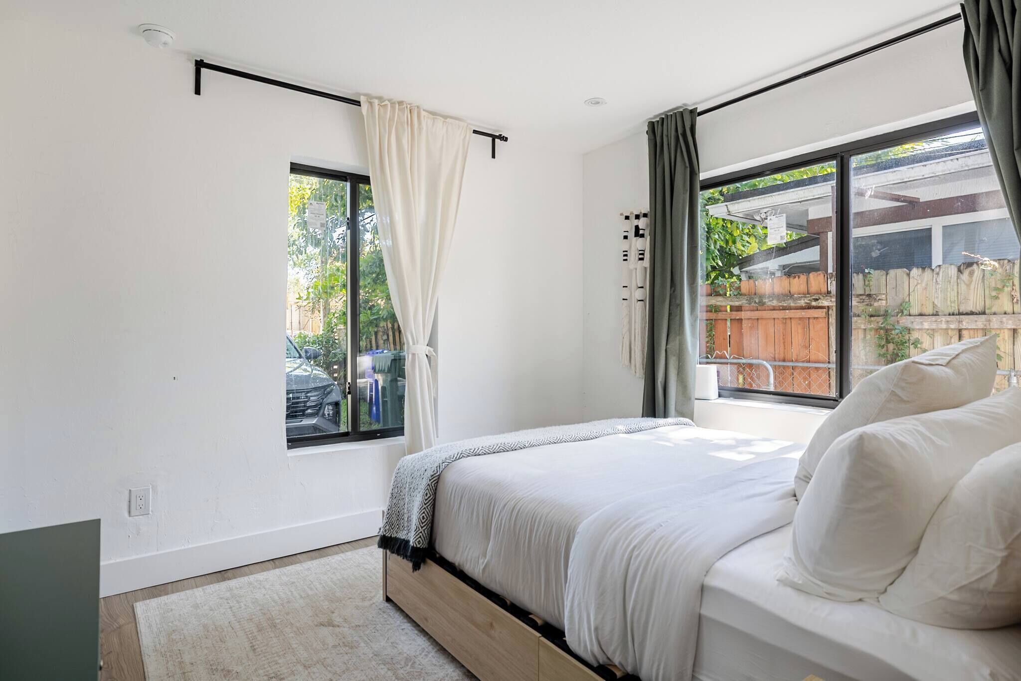 A bedroom with a bed, a window, and a view of the outside.