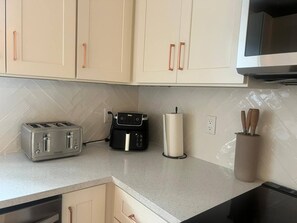 A kitchen with white cabinets, a toaster, a coffee maker, and a microwave. - 4BR Miaminear Design Districtbig Yard & Fire Pit (Miami)