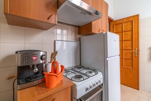 Eine Küche mit Herd, Backofen und Kaffeemaschine.