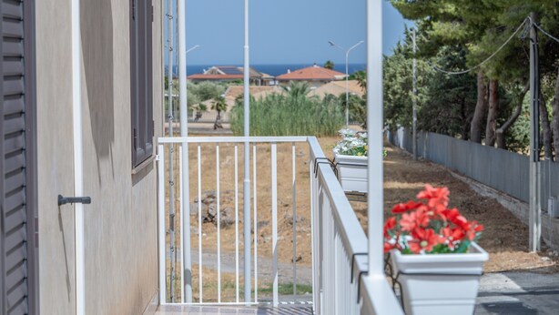 A balcony with a metal railing, a view of a residential area, and a clear sky. - Apartment Lucia with Sea View, Wi-Fi, and Air Conditioning (Avola)