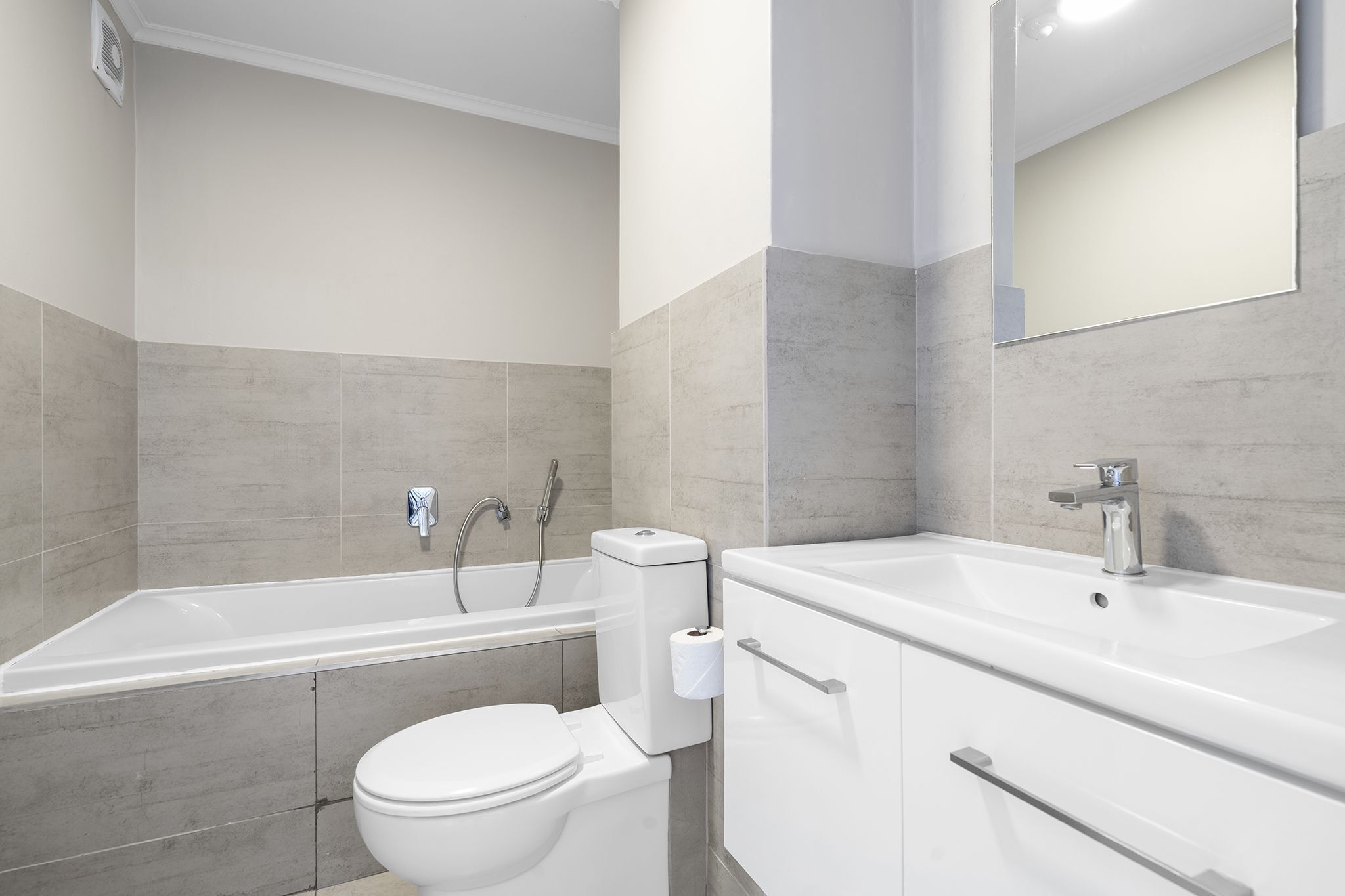 Ein modernes Badezimmer mit Badewanne, Toilette und Waschbecken.