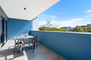 A balcony with a table and chairs, a bottle, and a glass. - The Terraces 220 - Two Bedroom Apartment, Sleeps 4 (Cape Town)